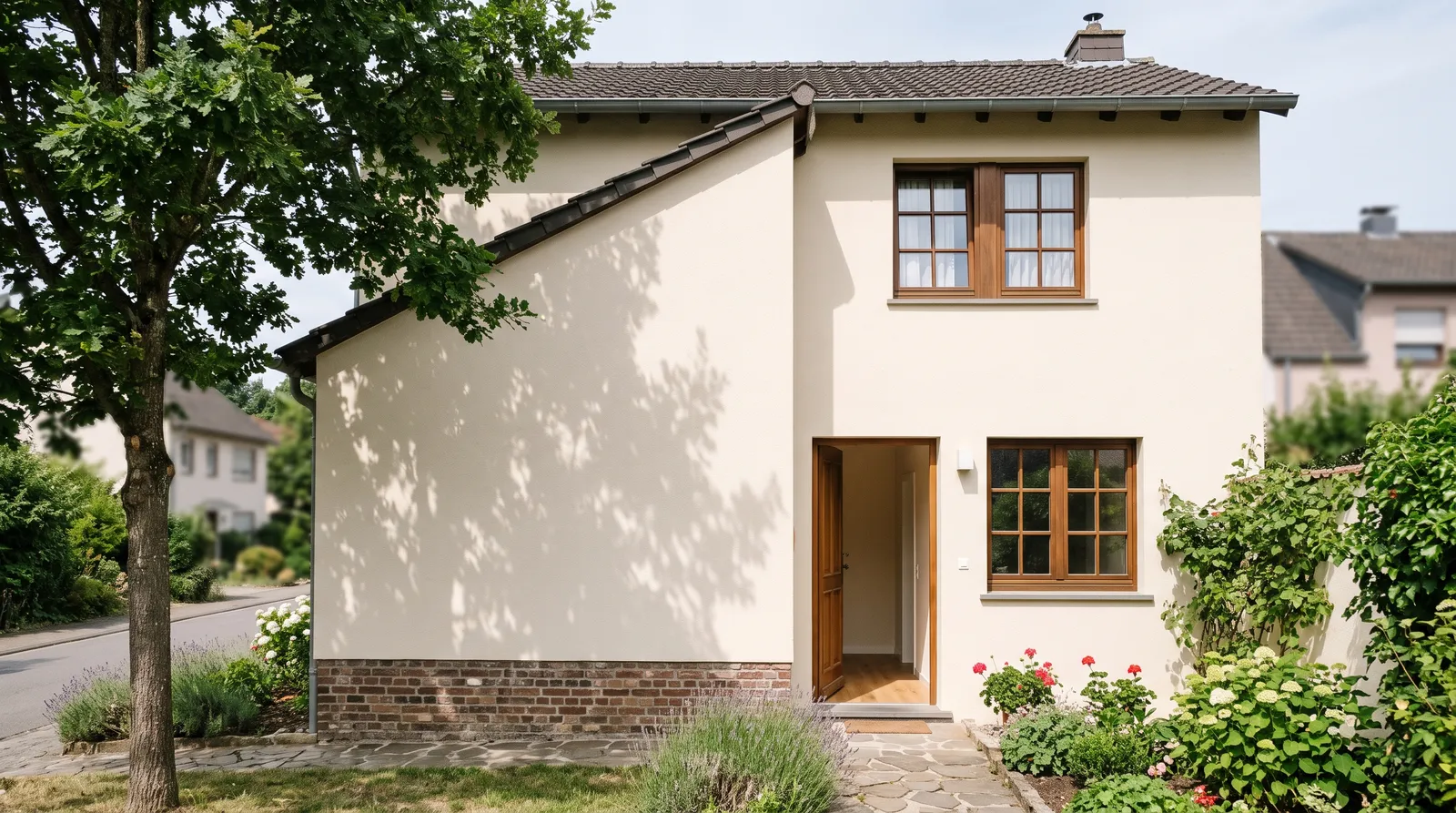 Freshly painted rendered masonry facade on a two-story house in morning daylight, with a matte interior wall visible through an open doorway