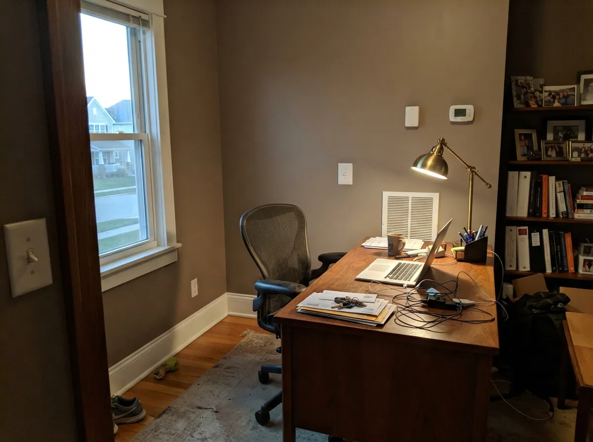 Under evening lamplight the taupe turns cozy and settled — its best room is the one people actually use after dark.