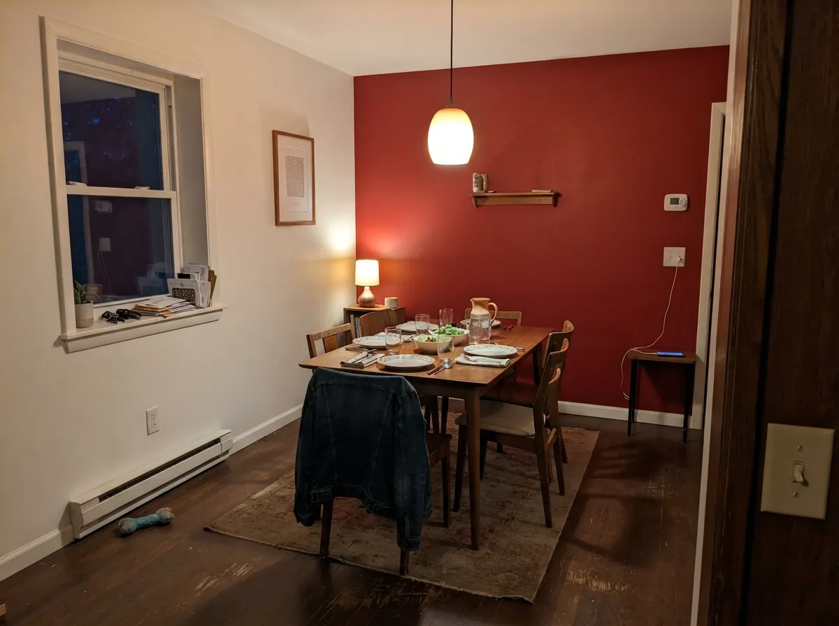 One accent wall, warm lamplight — the red glows instead of closing the room in.