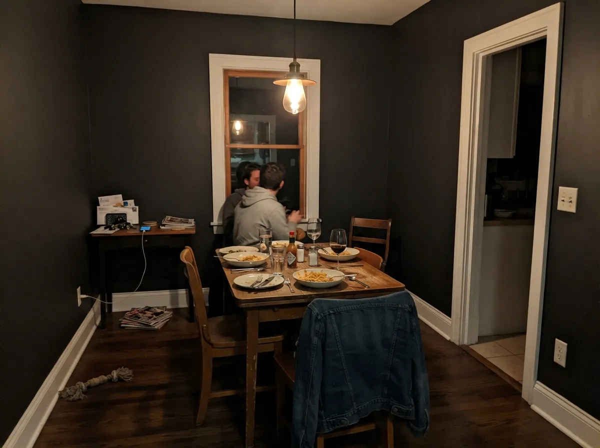 The room it was built for: a dining room used mostly after dark, where the walls disappear into shadow between the light and glow warm right where the pendant hits them.