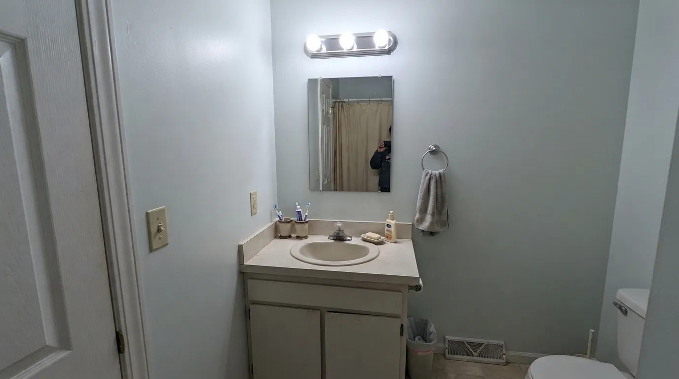The honest shot: with no daylight and only cool bulbs, the color loses its green and goes flat gray-blue — the situation to test hard before painting a windowless room.