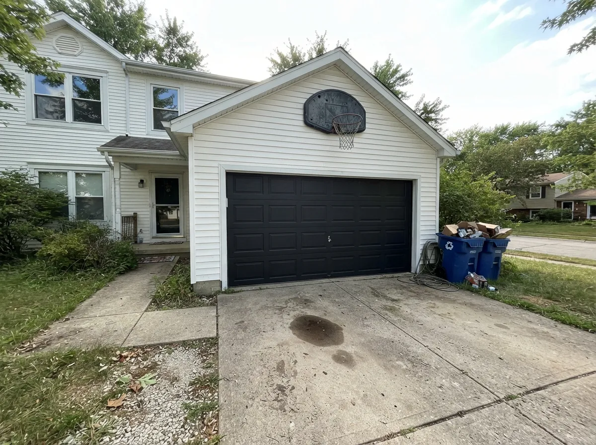 A black garage door under light siding is the cheapest curb-appeal upgrade there is — check your door's paint rules before you commit.