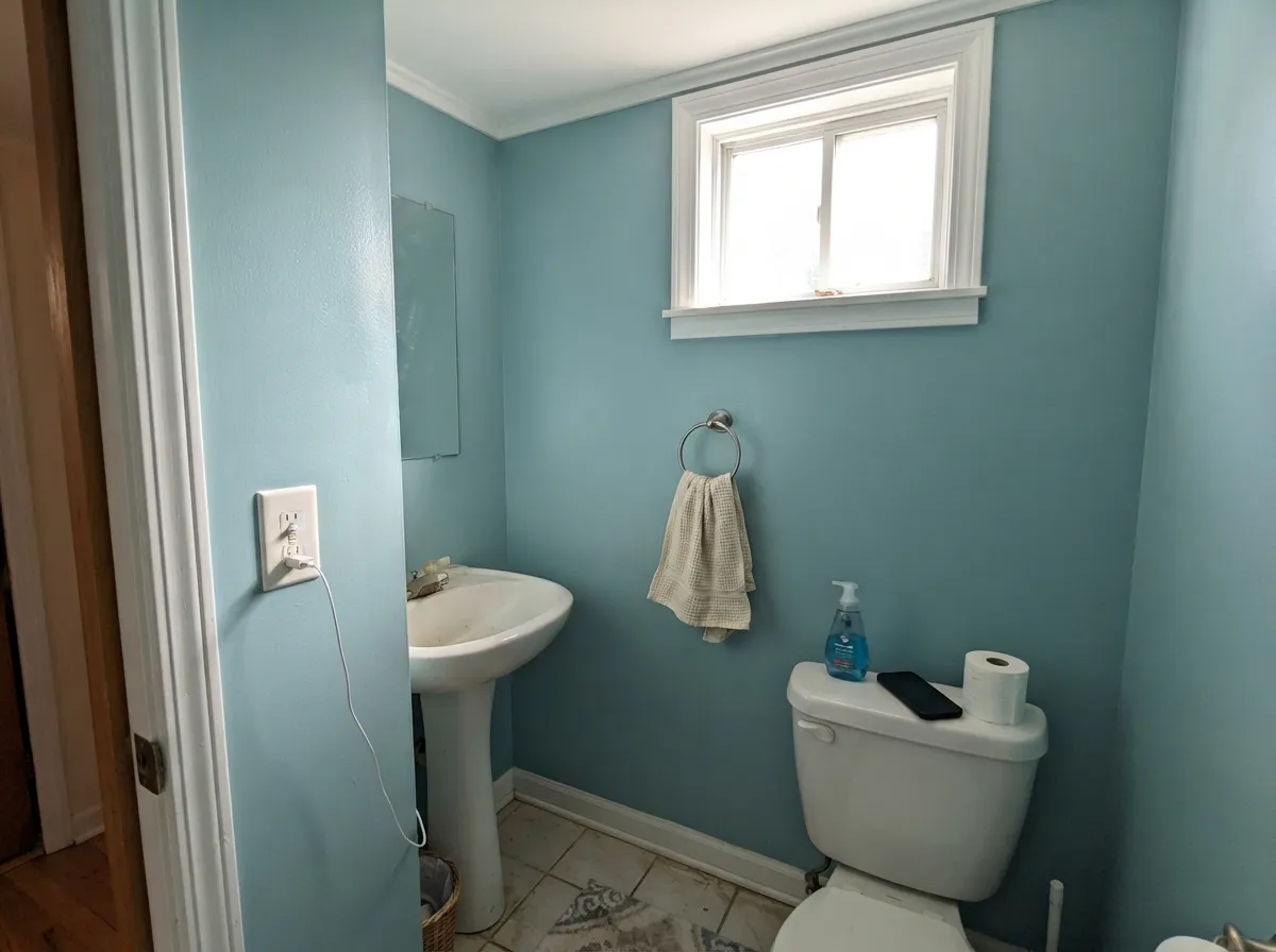 Small rooms take the mid-tone well — four walls of Dolphin Blue read considered, not leftover, if the ceiling stays bright white.