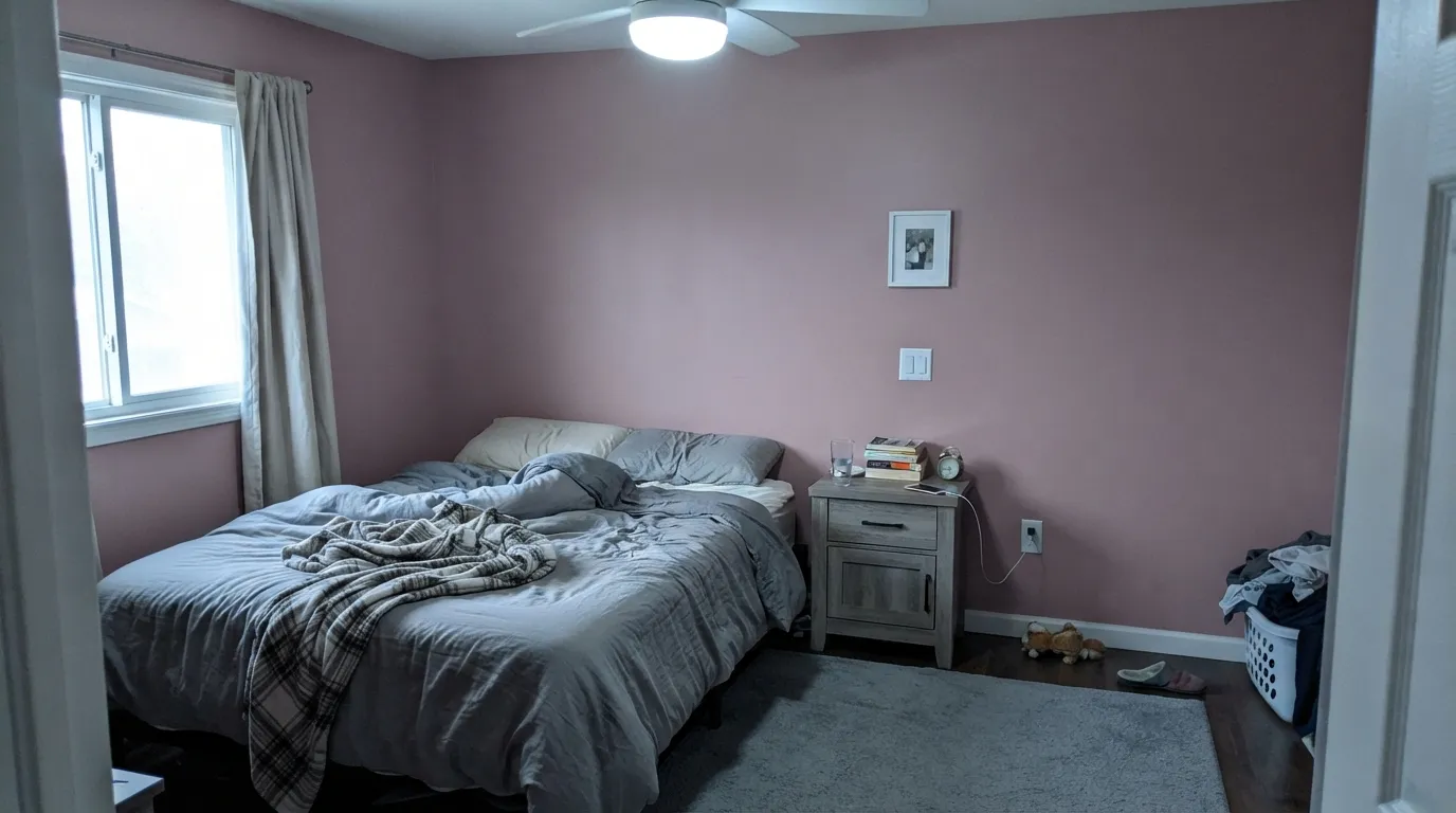 The honest shot: cool overcast light and a cool gray rug pull the pink-beige undertone forward and the wall reads dusty rose, not mocha — the exact surprise buyers report.