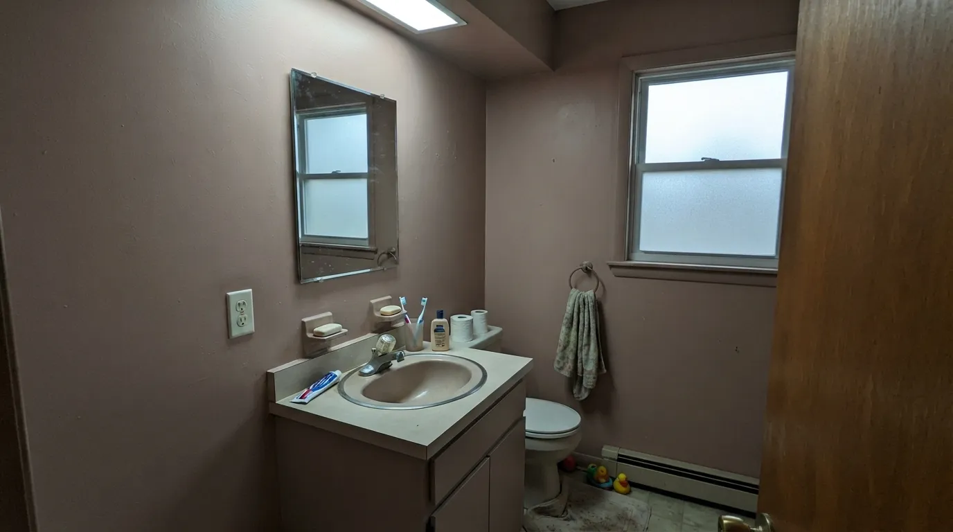 The honest shot: cool LED light and chrome fixtures drain the pink out entirely, leaving a dull, muddy taupe — the exact combination behind the disappointed reviews.