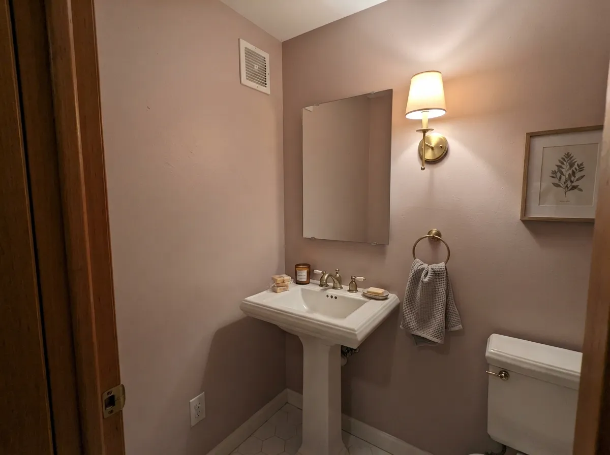 Its second-best job: a windowless powder room under warm brass light, where the pink reads expensive instead of sweet.