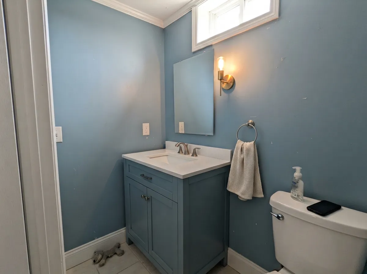 Small rooms take LRV 31 well — a Teton Blue vanity under a warm sconce looks custom, not cave-like, if the ceiling stays bright white.