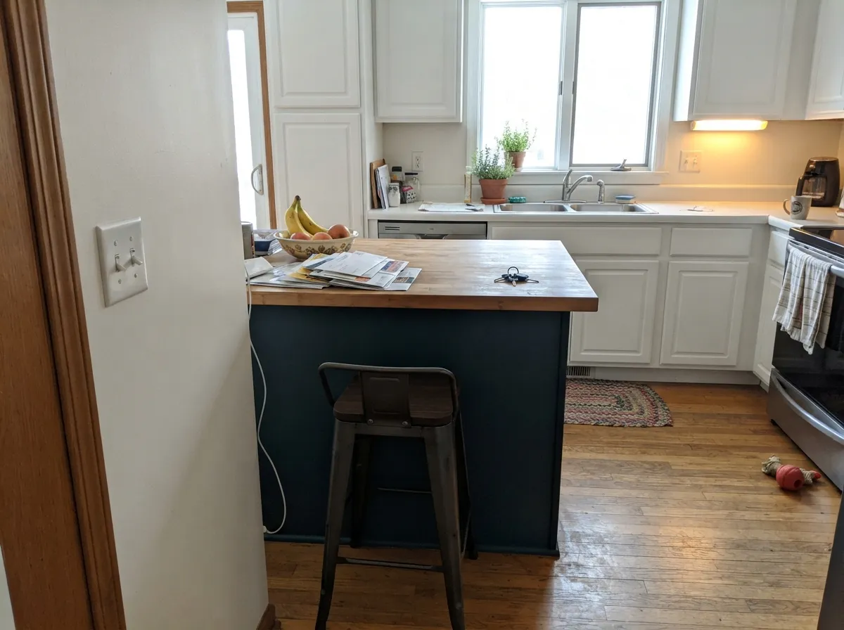 Its strongest kitchen job: one island against light perimeter cabinets, getting daylight from every side.