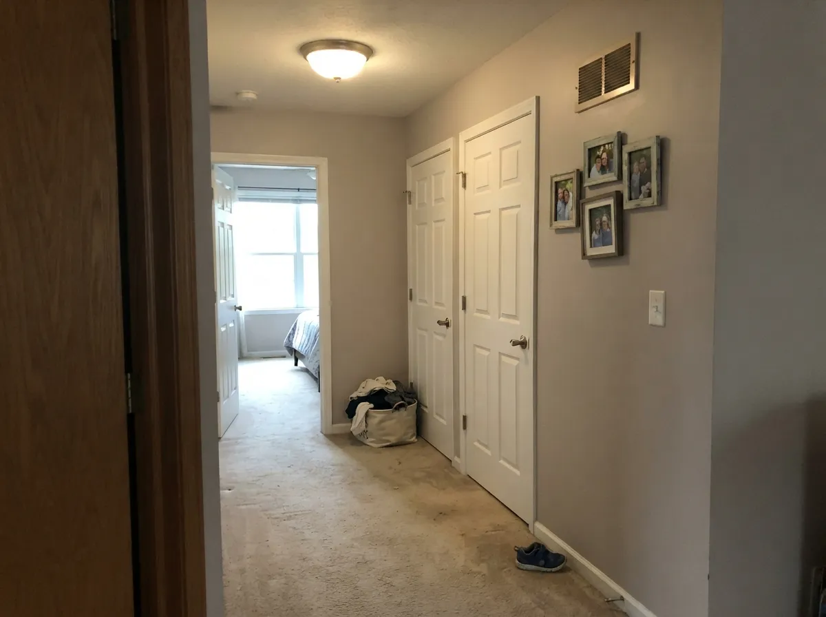 In a windowless hallway it still gives light back, and the white doors keep it from sliding toward beige.