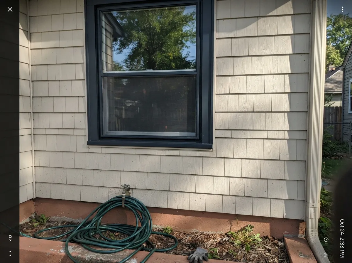 A full run of black window frames draws a crisp, consistent line around the house — the look this color built its reputation on.