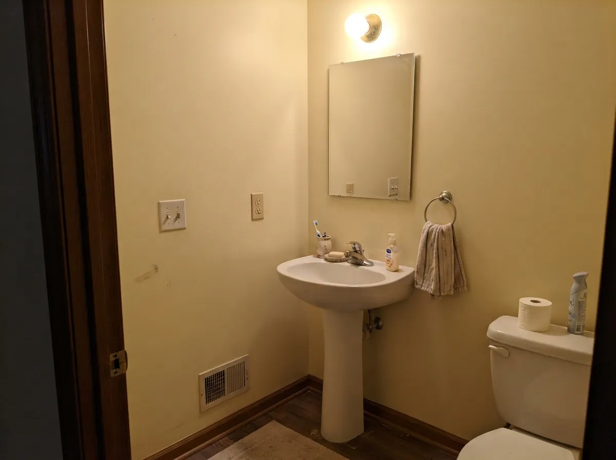 Small rooms with no view to lose are the easy win — under a warm bulb a windowless powder room reads lit rather than closed in.