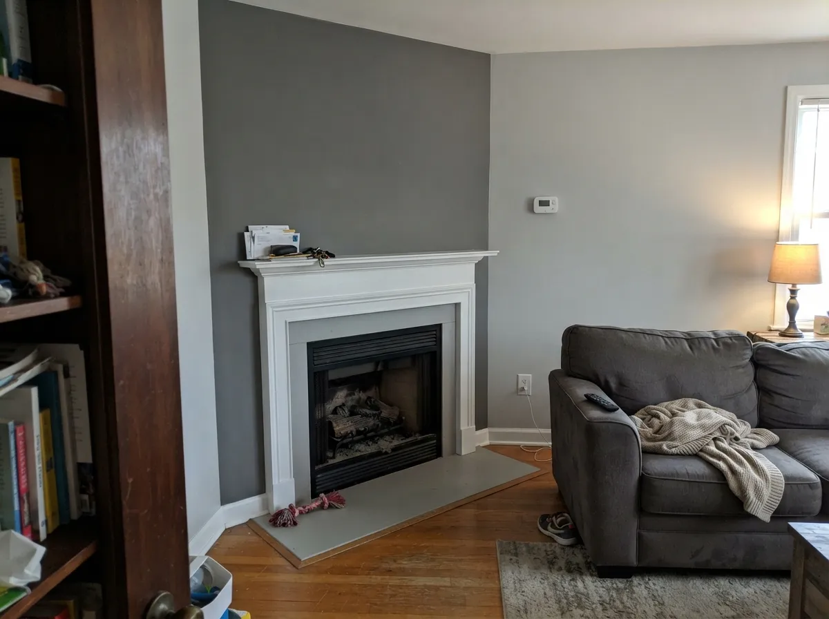 One fireplace wall in daylight — Cinder as a charcoal decision against Classic Gray, not a four-wall drench.
