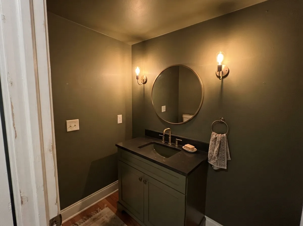 In a windowless powder room there is no daylight to lose, so the color is free to go as dark as it likes.