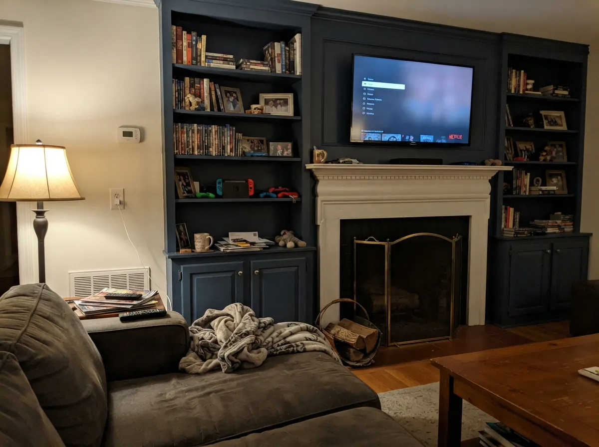 Built-ins at night under warm lamps: the navy goes rich, not black — this is the depth people pay for.