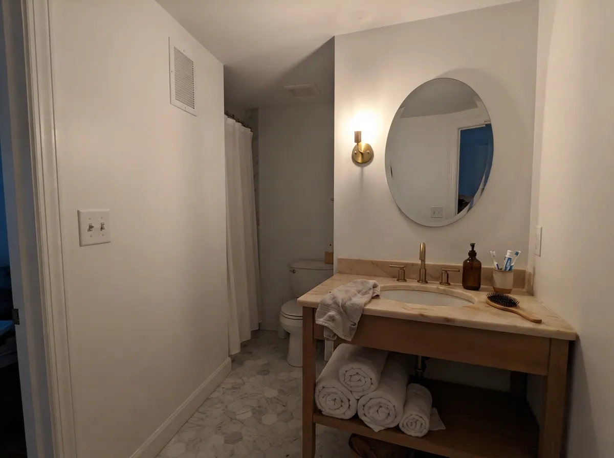Simply White bathroom walls with warm marble and brass fixtures.