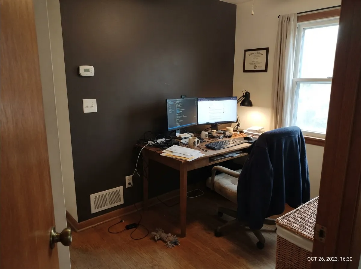 One well-lit office wall is the interior version of the cabinet job — the charcoal holds, the brown shows where the window hits.