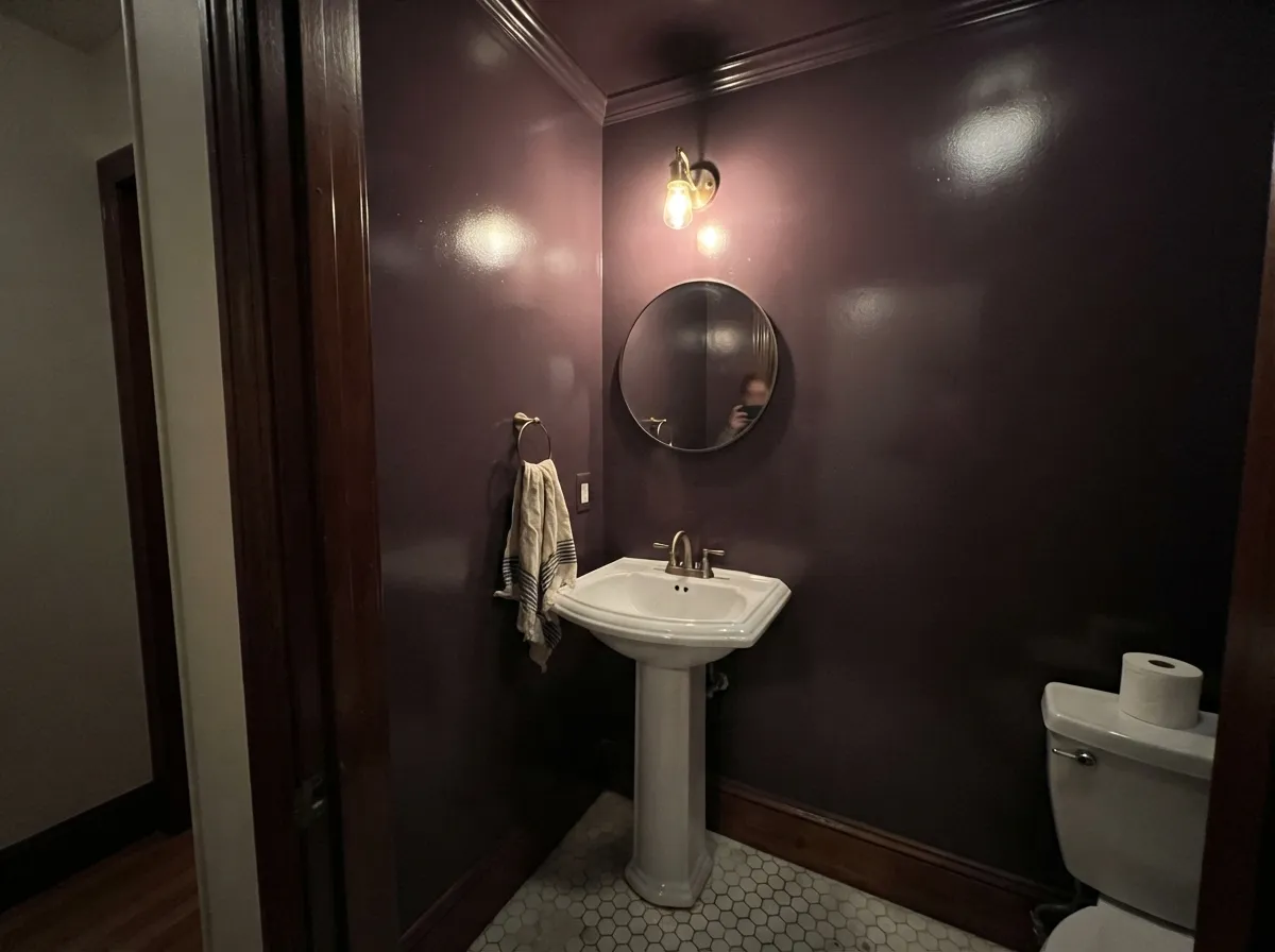 Drenched floor to ceiling in gloss: the powder room is where losing daylight costs nothing and the shine does the work.