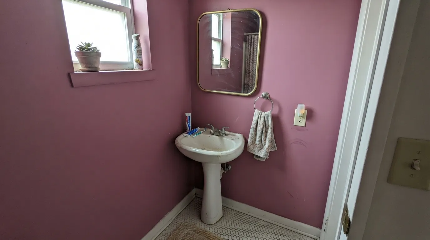 Fuscia Fizz earning its keep: a closed powder room in real daylight, dusty magenta on every wall, White Dove keeping the edges soft.