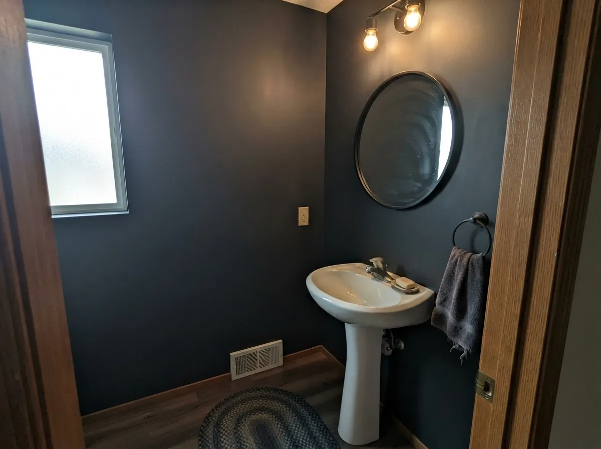 A small room with real daylight is where the depth pays off instead of turning into a cave — this is the powder-room move.