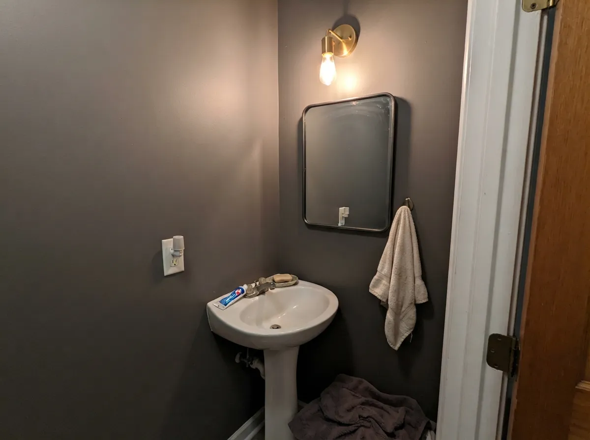 Lamps-only powder room: Cinder reads as stone, not a cave, once the bulbs are warm and the trim stays cream.