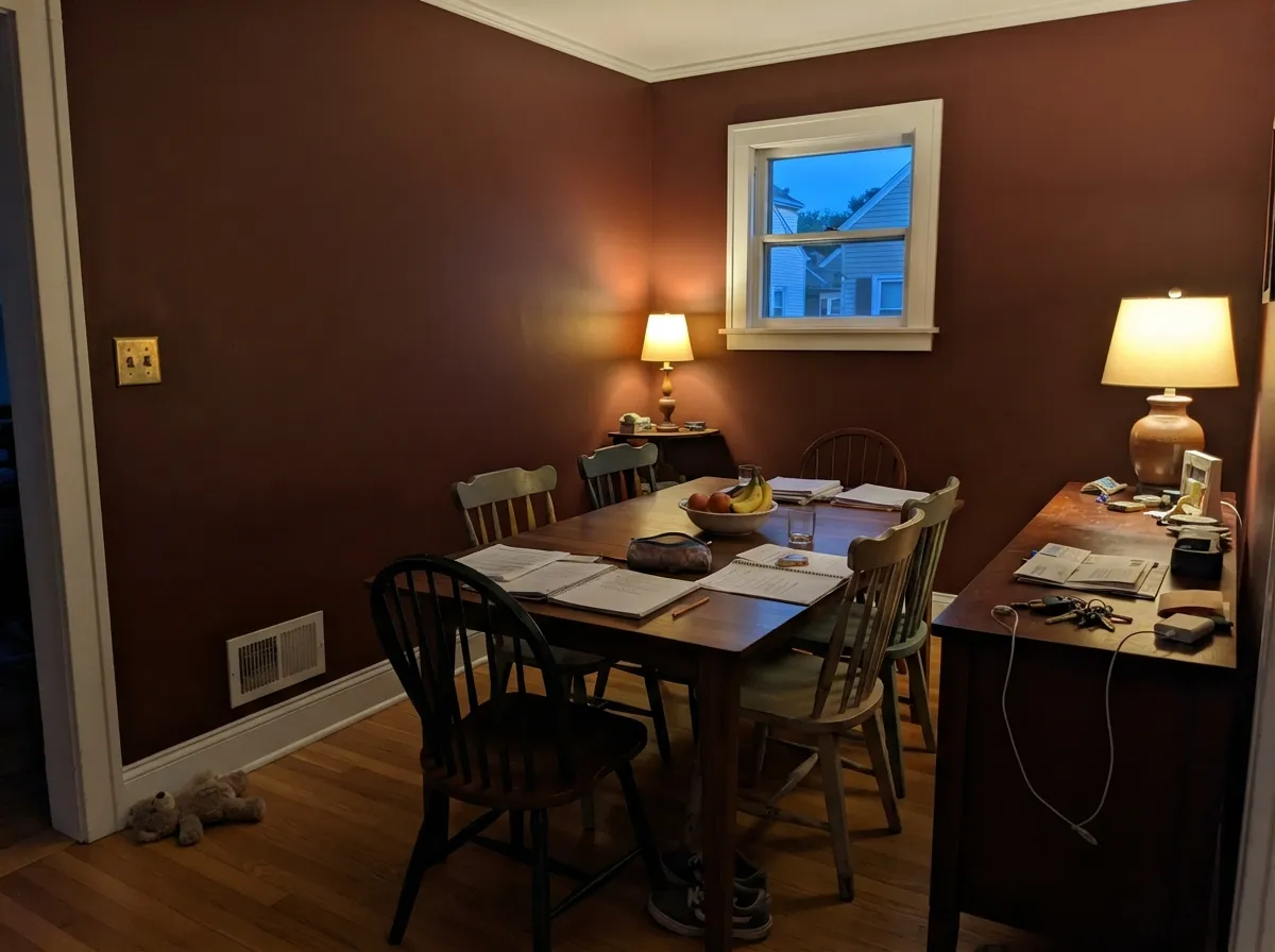 The wood-tone dining room this chip belongs in — lamps on, walnut in the room, and the walls go wine-dark instead of cave-black.