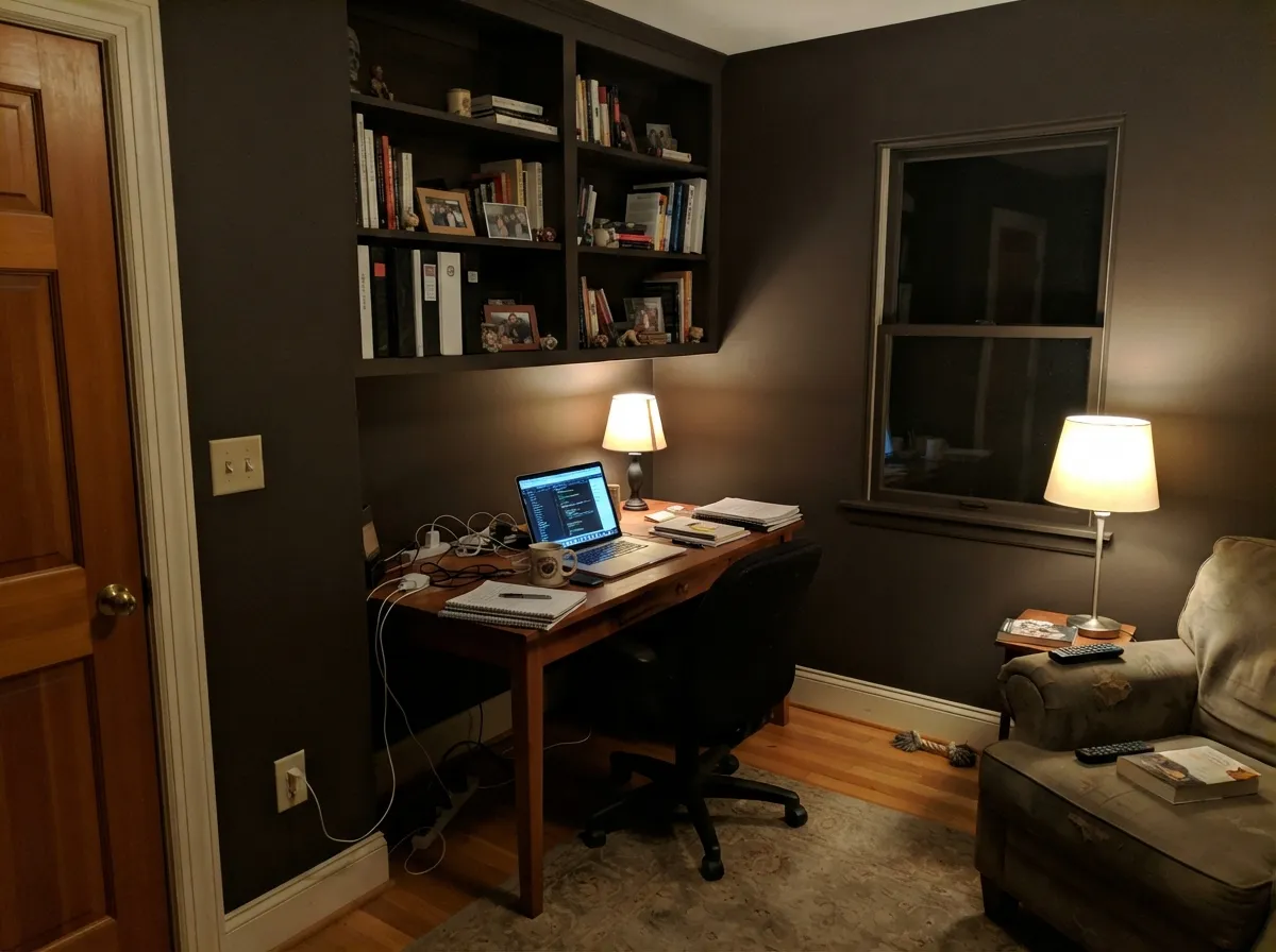 Under warm 2700K lamps the walls go rich and brown rather than flat black — dark rooms like this live or die on the bulbs.