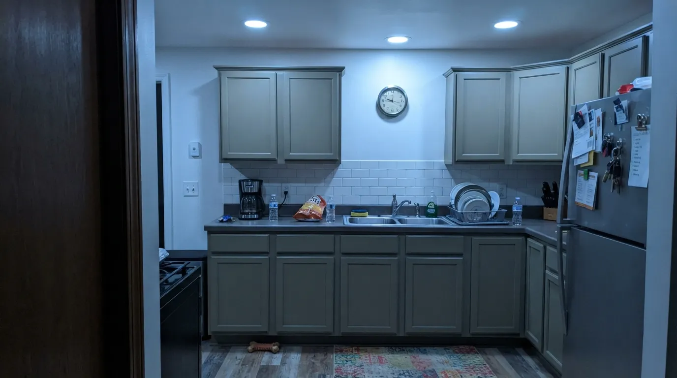The honest shot: under cool 4000K bulbs the green drains out and the cabinets go drab olive-gray — the exact complaint people post after painting.