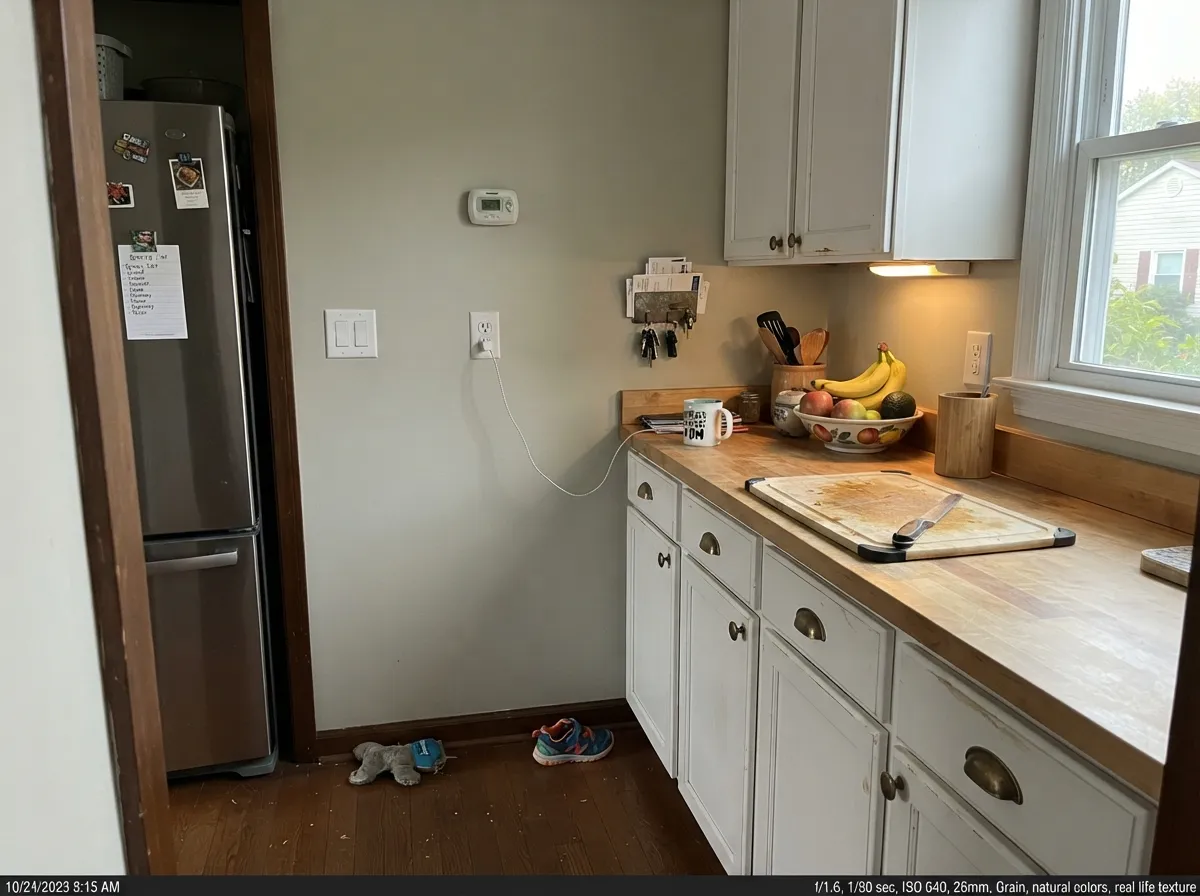 Behind white cabinets the green stays quiet and lets the cabinets do the talking — its best interior job after open-plan walls.