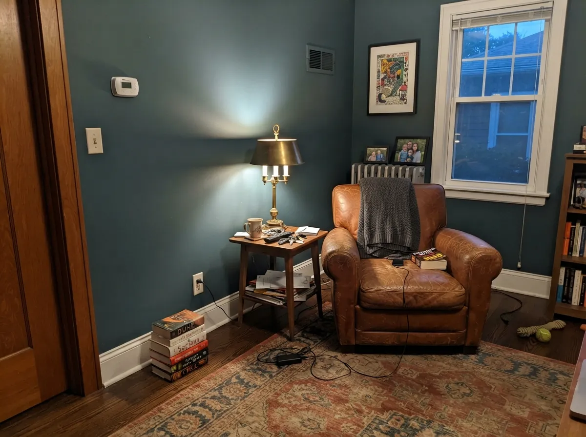 Under lamp light in a closed room the green settles into a warm, cocooning charcoal — not heavy, just quiet.
