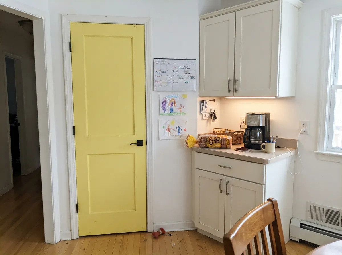 One quart, one door: against warm white cabinets the lemon still reads clearly yellow from across the kitchen, which is the whole reason to pick a saturated yellow over a butter one.