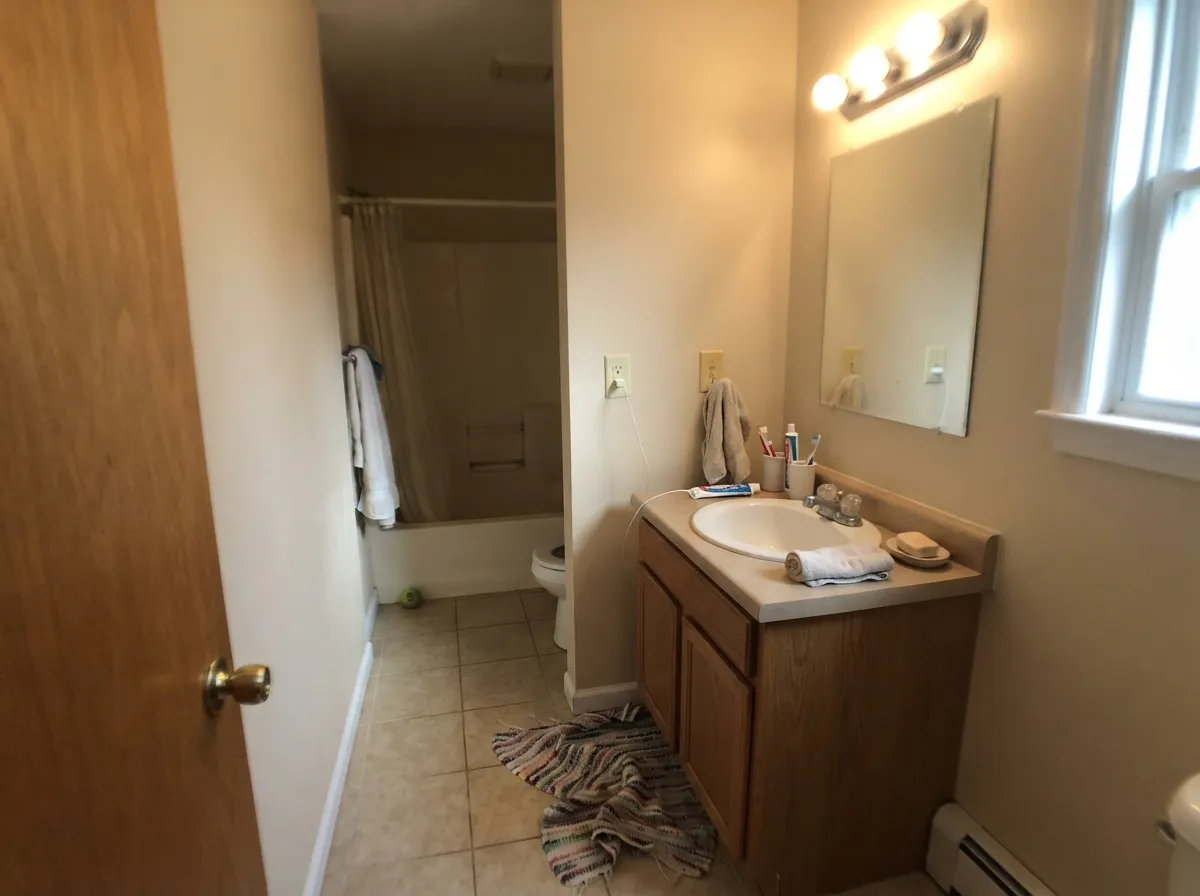 Natural Linen bathroom walls with tan porcelain tile and a wood vanity.