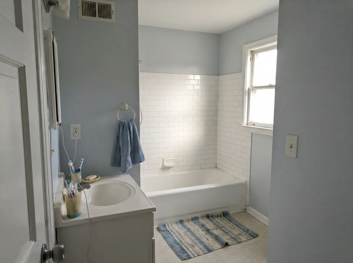 In a small, light-filled bathroom it lifts the room without going stark white — the LRV 68 brightener at work.