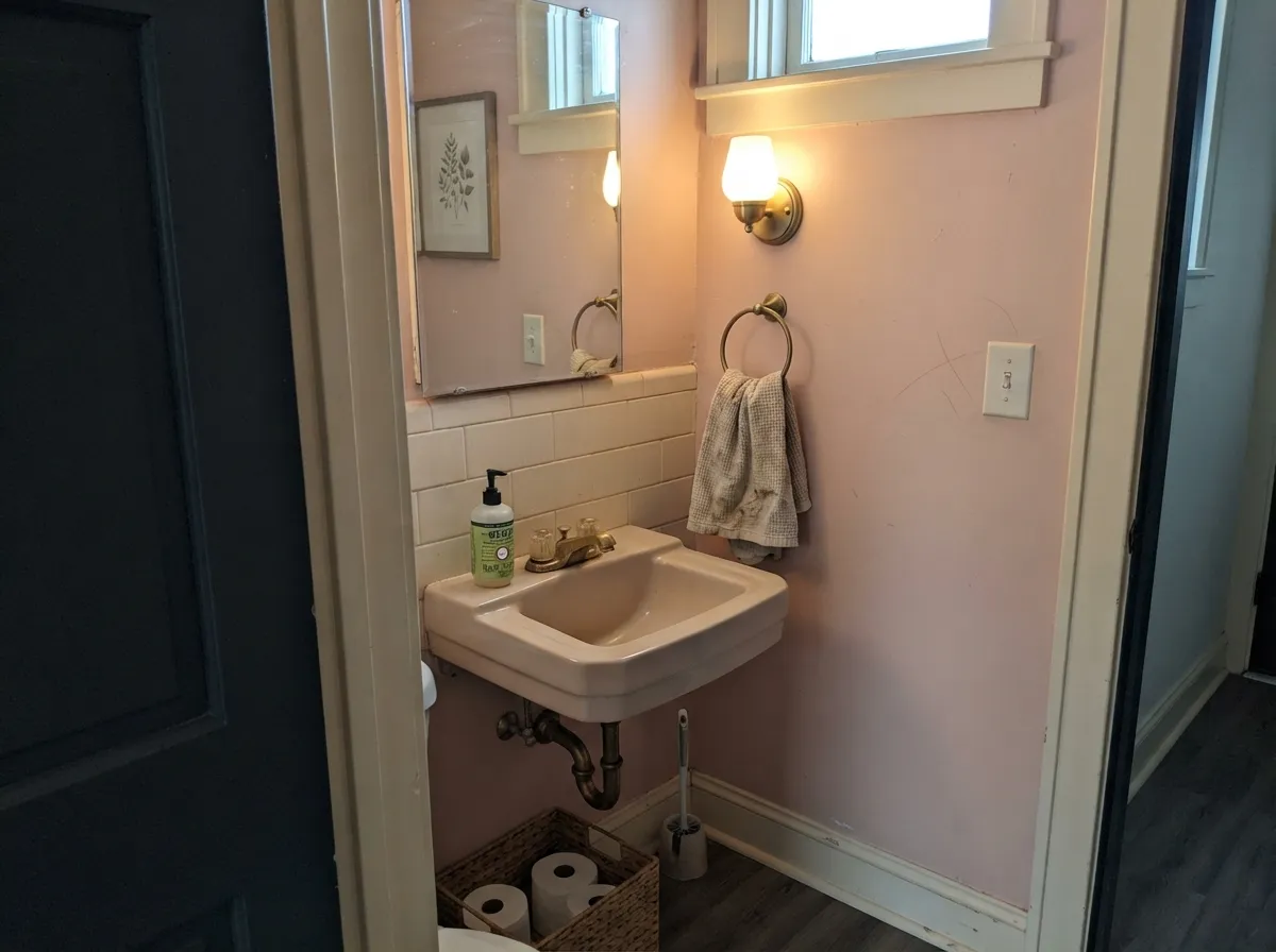 In a powder room the warm pink reflects onto faces in the mirror — the old-house reason blush shows up in small rooms and dining rooms.
