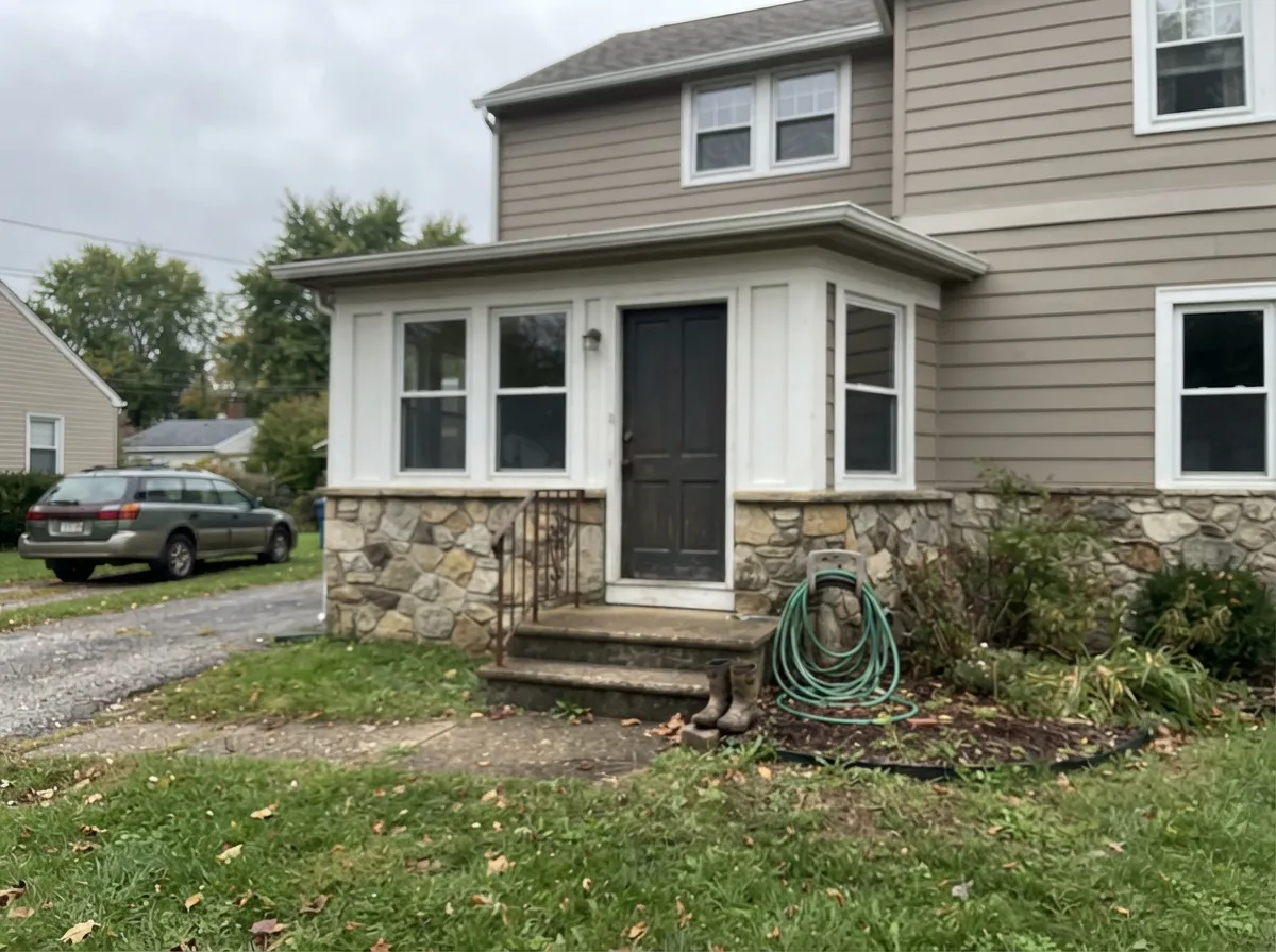 One of its best jobs: against real stone and a crisp white trim, Popular Gray reads calm and substantial outdoors.