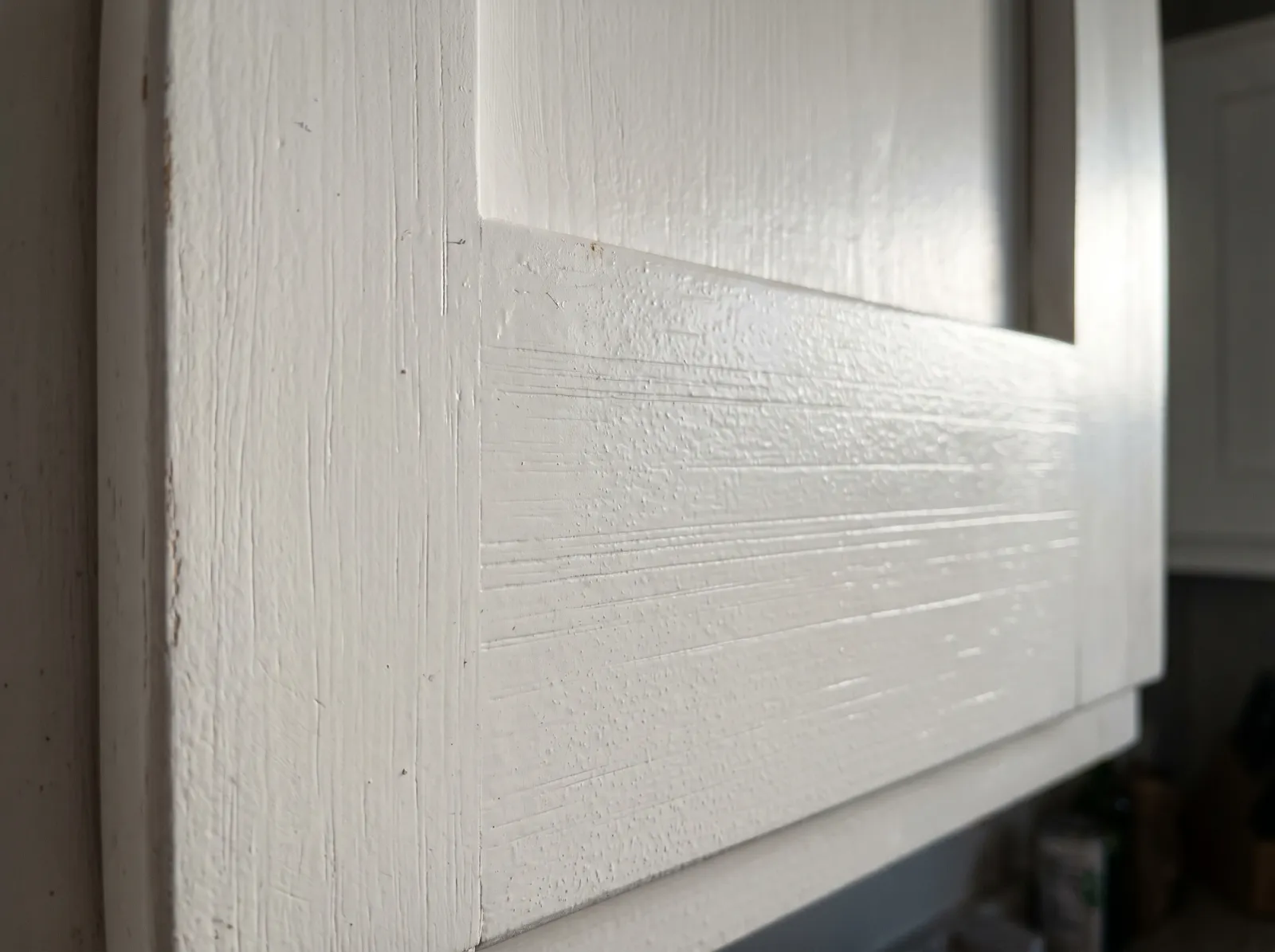 Close-up of cabinet door surface showing foam roller streaks and light stipple