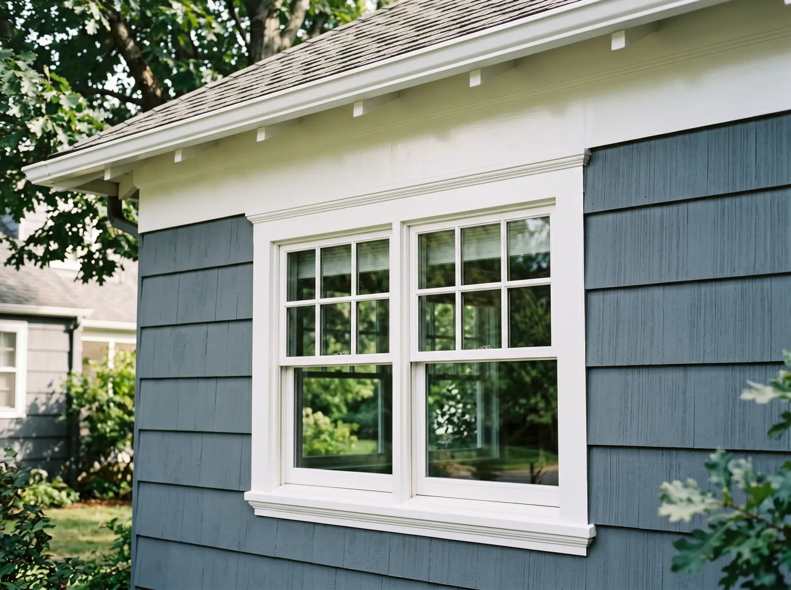 Exterior trim with finished second coat of white enamel and a sharp clean line against siding