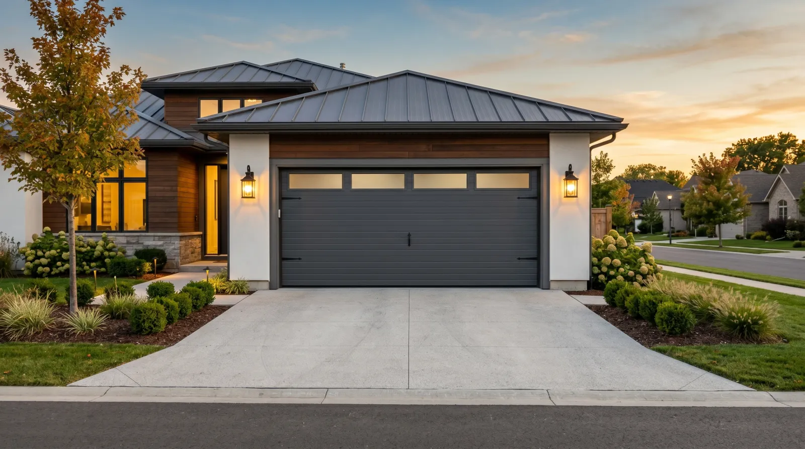 Finished charcoal garage door at golden hour with masking removed and coach lights on